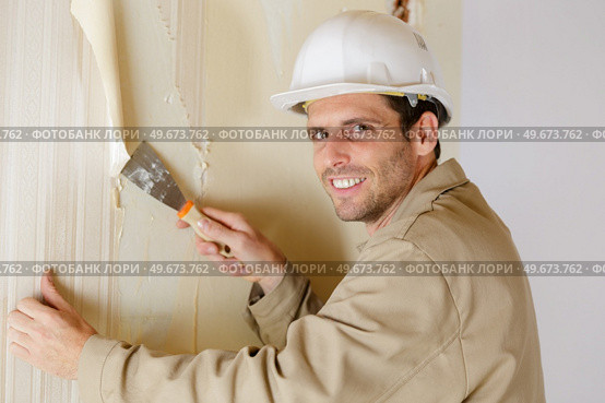a man removing the wallpaper. Стоковое фото, агентство Ingram Publishing / Фотобанк Лори
