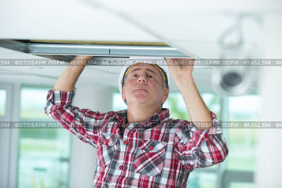 a man repairing collapsed ceiling. Стоковое фото, агентство Ingram Publishing / Фотобанк Лори