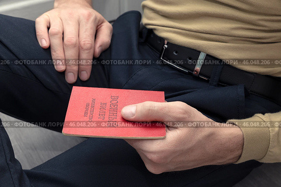 A man with a military ID in his hands sits on the floor. Стоковое фото, фотограф Дмитрий Кобзев / Фотобанк Лори