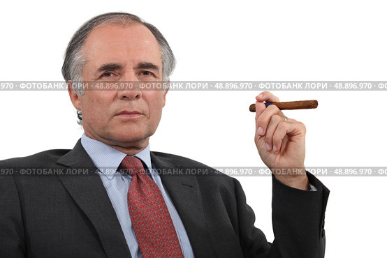 A mature businessman smoking a cigar. Стоковое фото, агентство Ingram Publishing / Фотобанк Лори