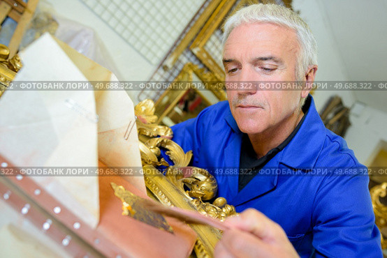 a mature male goldsmith making ornamental picture frames. Стоковое фото, агентство Ingram Publishing / Фотобанк Лори
