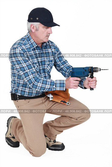 A mature man with a driller. Стоковое фото, агентство Ingram Publishing / Фотобанк Лори
