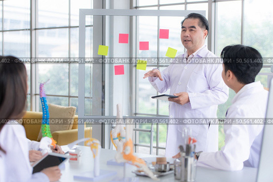A medical professor is lecturing on a case study related to disease treatment to medical students. Стоковое фото, агентство Ingram Publishing / Фотобанк Лори