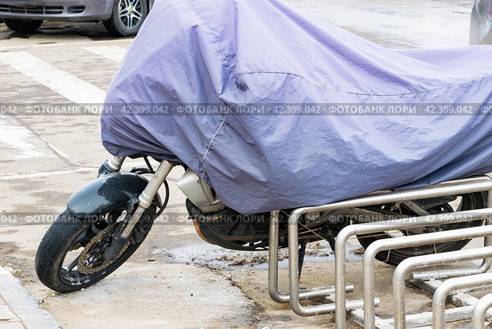 A motorcycle in a case in the parking lot. the beginning or end of the motorcycle season. close-up. Стоковое фото, фотограф Антон Вахрушев / Фотобанк Лори