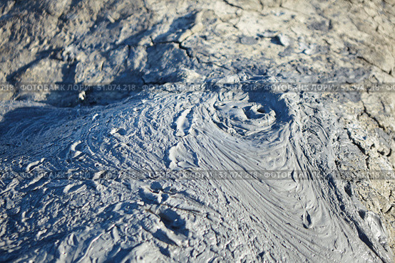 A mud volcano and a stream of grey clay from an eruption and gas escape. Cracked soil surface. Texture of a mudflow. Стоковое фото, фотограф Наталия Кирсанова / Фотобанк Лори