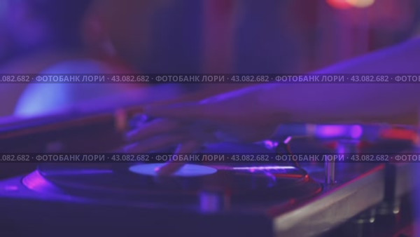 A person is playing a record player with a purple background. Стоковое видео, видеограф Константин Шишкин / Фотобанк Лори
