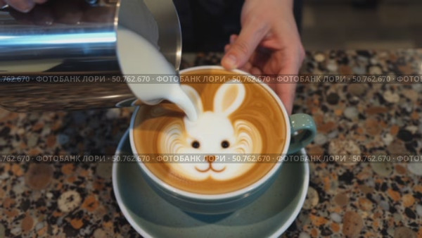 A person is pouring milk into a coffee cup with a rabbit face on it. Стоковое AI-видео, аниматор Виктория Кольцова / Фотобанк Лори