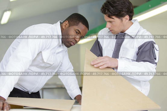 a portrait of two workmen checking wood. Стоковое фото, агентство Ingram Publishing / Фотобанк Лори
