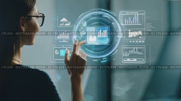 A professional woman engages with augmented reality graphics to analyze data insights in a contemporary office environment. Стоковое AI-видео, аниматор Данила Большаков / Фотобанк Лори