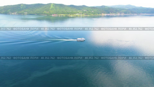 A ship with tourists goes along Lake Baikal. View of the village of Listvyanka. Стоковое видео, видеограф Виктория Тельминова / Фотобанк Лори