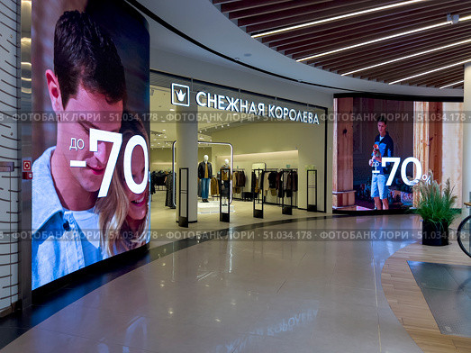 A shop window with a large sign that says "70". The sign is shining brightly, but the store is empty. Russia. Moscow. 08.08.25. Редакционное фото, фотограф Ярославский Максим / Фотобанк Лори