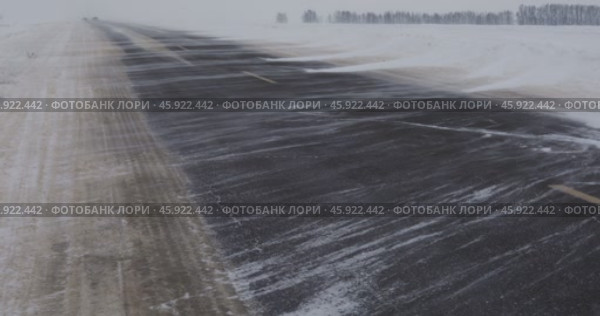 A snowstorm covers the road, narrows the roadway. Стоковое видео, видеограф Сергей Чайко / Фотобанк Лори