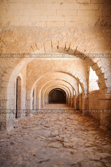 A stone corridor with a series of symmetrical arches, of a Arkadi Monastery. Стоковое фото, фотограф Artem Fomin / Фотобанк Лори