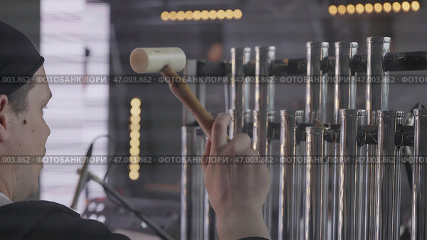 A talented musician passionately playing a percussion instrument at a vibrant music event. Стоковое фото, фотограф David Kashakhi / Фотобанк Лори