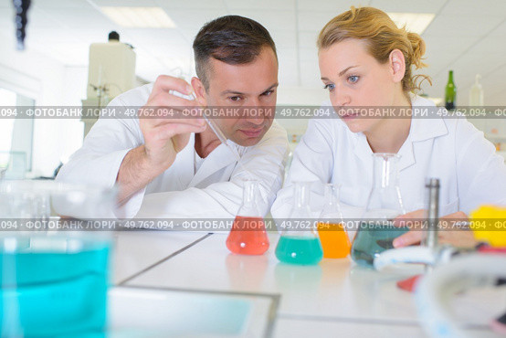 a team of lab chemists checking solutions. Стоковое фото, агентство Ingram Publishing / Фотобанк Лори