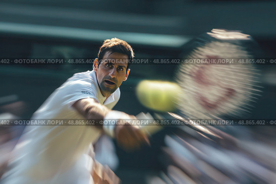 A tennis player is in the middle of a serve, with his racket in the air. Стоковое фото, фотограф Ярославский Максим / Фотобанк Лори