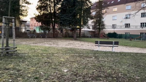 A tranquil urban park featuring swings, multiple benches, and vibrant green surroundings. Стоковое видео, видеограф Vladimir Vintonjak / Фотобанк Лори