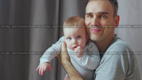 A warm moment between parent and child, showing a tender embrace. A father holds his young son in his arms and kisses him. Close-up. Стоковое видео, видеограф Воловодов Владимир / Фотобанк Лори