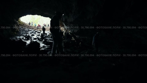 A wet rocky cave. People explorers walking down in the dark. Стоковое видео, видеограф Константин Шишкин / Фотобанк Лори