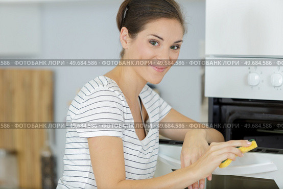 a woman cleaning an oven. Стоковое фото, агентство Ingram Publishing / Фотобанк Лори