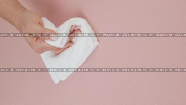 A woman's hand wipes water drops from a beige rug with a white cloth. Стоковое видео, видеограф Катерина Белякина / Фотобанк Лори
