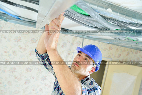 a worker is routing cables. Стоковое фото, агентство Ingram Publishing / Фотобанк Лори