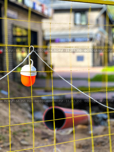 A yellow-orange lantern is hanging from the fence. Russia. Moscow. 05.09.25. Редакционное фото, фотограф Ярославский Максим / Фотобанк Лори