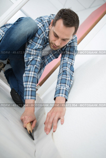 a young handyman installing linoleum. Стоковое фото, агентство Ingram Publishing / Фотобанк Лори