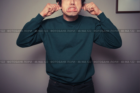 A young man is gesturing and pulling silly faces. Стоковое фото, агентство Ingram Publishing / Фотобанк Лори