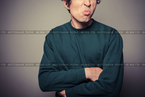 A young man is gesturing and pulling silly faces. Стоковое фото, агентство Ingram Publishing / Фотобанк Лори