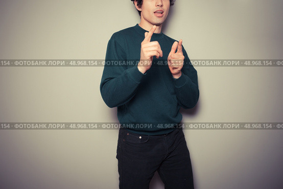 A Young man thinks he is cool and is making urban gestures with his hands. Стоковое фото, агентство Ingram Publishing / Фотобанк Лори