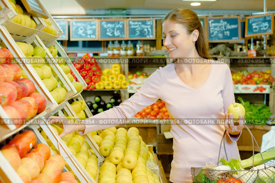 a young woman buying apples. Стоковое фото, агентство Ingram Publishing / Фотобанк Лори