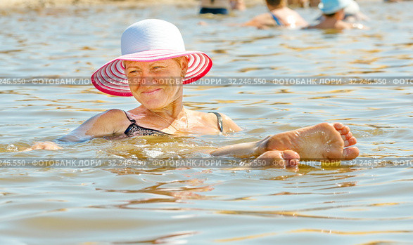 A young woman lies on the surface of a salt lake, a procedure, a treatment. Стоковое фото, фотограф Акиньшин Владимир / Фотобанк Лори