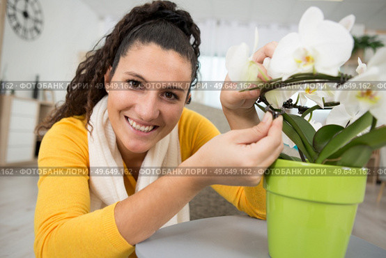 a young woman tends to her houseplants. Стоковое фото, агентство Ingram Publishing / Фотобанк Лори