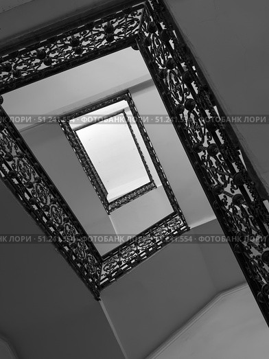 Abstract upward view of staircase with ornate iron railings. Стоковое фото, фотограф Антон Гвоздиков / Фотобанк Лори