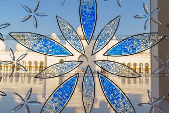 Abu Dhabi, United Arab Emirates - Jan 10 2024, Close-up view of the stained glass window with a floral pattern, in the Grand Mosque of Sheikh Zayed, at daytime, Abu Dhabi, United Arab Emirates. Редакционное фото, фотограф Сергей Богомяко / Фотобанк Лори