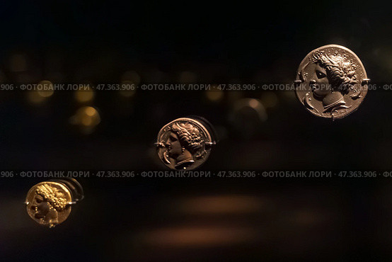 Abu Dhabi, United Arab Emirates - Jan 17 2024, Close-up view of the ancient antique coins in the Louvre Abu Dhabi Museum, belonging to different eras, Abu Dhabi, United Arab Emirates. Редакционное фото, фотограф Сергей Богомяко / Фотобанк Лори