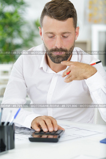 accountant calculating dollars with calculator in office. Стоковое фото, агентство Ingram Publishing / Фотобанк Лори