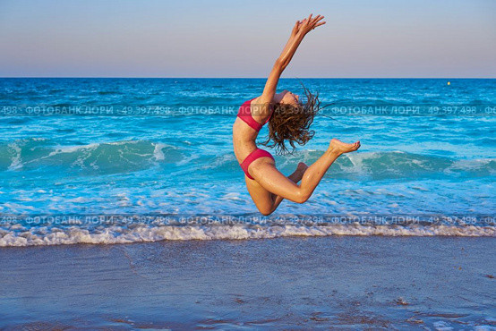 acrobatic gymnastics bikini girl in a beach blue shore at summer. Стоковое фото, агентство Ingram Publishing / Фотобанк Лори