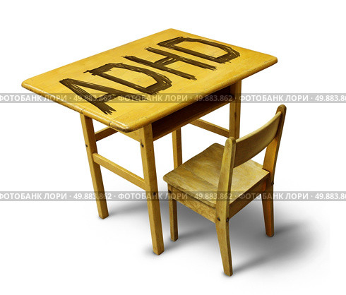 ADHD Concept for hyperactivity disorder and attention deficit  behavior as a school desk with the letters carved into the wooden table as a healthcare symbol for childhood mental health issues. Стоковое фото, агентство Ingram Publishing / Фотобанк Лори