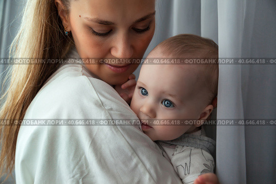 Adorable newborn baby on hands loving happy mother at home, looking away. Mommy with kid together in room. Mum care 6 months old infant child. Concept of motherhood, maternity. Copy ad text space. Стоковое фото, фотограф Aleksandr Golubev / Фотобанк Лори