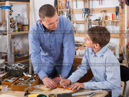adult father teaching son сarpentry in the garage. Стоковое фото, фотограф Яков Филимонов / Фотобанк Лори