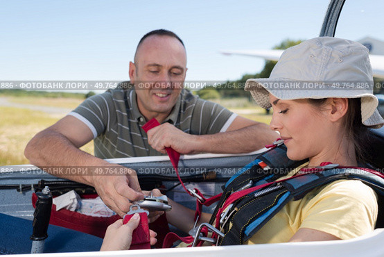 adventurous woman being strapped into sailplane. Стоковое фото, агентство Ingram Publishing / Фотобанк Лори