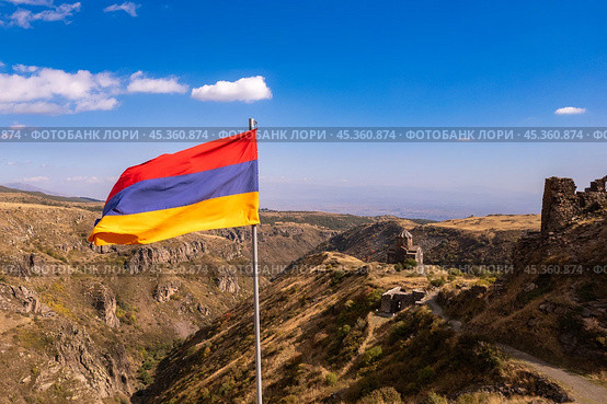 Aerial drone view to flag of Armenia and famous Vahramashen Church of the 11th century, near Amberd fortress in sunny summer day. Cliff with Arkashian River deep in canyon. Aragatsotn region, Armenia. Стоковое фото, фотограф Алексей Ширманов / Фотобанк Лори