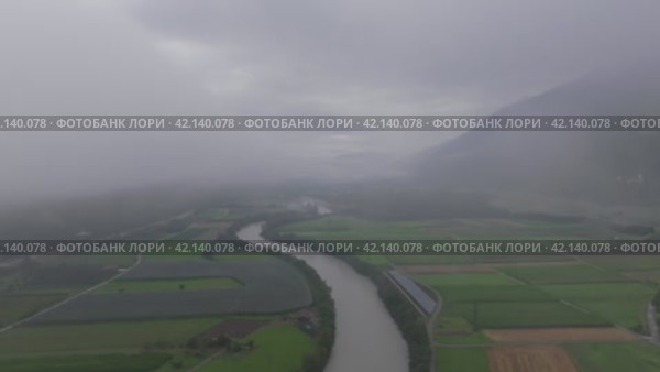 Aerial motion from right to left over river entering fog in Dolomites Austria. Стоковое видео, видеограф Данил Руденко / Фотобанк Лори
