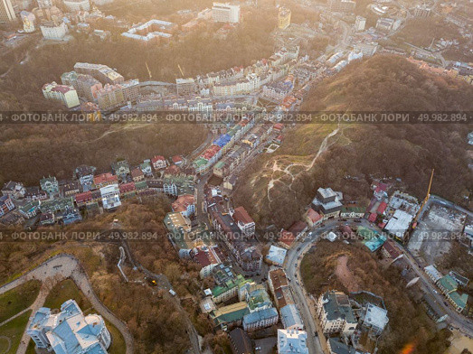 Aerial panoramic view from the drone, bird’s eye view to Vozdvizhenka, Andreevsky descent, National Museum of Ukrainian History at beautiful sunset in the summer.. A bird’s eye view, aerial view shooting from drone of the Podol district, oldest historical center of Kiev, Ukraine. Стоковое фото, агентство Ingram Publishing / Фотобанк Лори