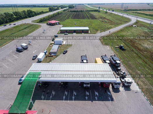 Aerial view at petrol station with trucks, passenger cars filling gas, it is located between two highways, plain terrain. Стоковое фото, фотограф Кекяляйнен Андрей / Фотобанк Лори