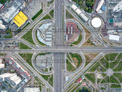 Aerial view city of Kiev, a modern road junction with cars, high-rise buildings, shopping centers with parking lots and green areas, Poznyaki district, Ukraine. Photo from the drone. Aerial view modern city of Kiev, a road junction with cars, Ukraine. Редакционное фото, агентство Ingram Publishing / Фотобанк Лори