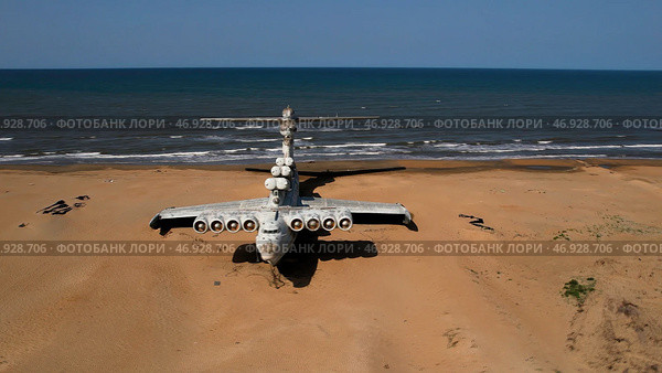 Aerial view of a ruined abandoned airplane found in an uninhabited island near the sea on blue sky background. Стоковое фото, фотограф David Kashakhi / Фотобанк Лори