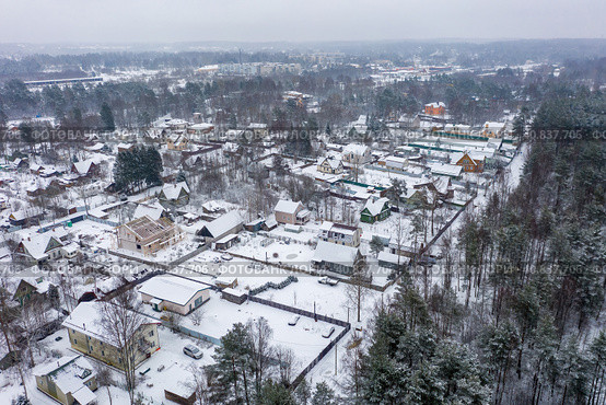 Aerial view of a snow-covered village. Winter rural landscape. Top view of the streets, houses and trees. Cold snowy winter weather. Snowfall. Snow on the roofs. Toksovo, Leningrad region, Russia. Стоковое фото, фотограф Андрей Степанов / Фотобанк Лори